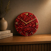 Red velvet clock with gold numbers on a wooden surface against a brown wall.