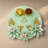 Decorative green plate with floral designs and gold accents on a beige background
