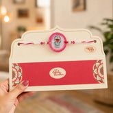 Rakhi with a card held by a hand, blurred indoor background