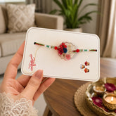 Hand holding a card with decorative items on a blurred indoor background