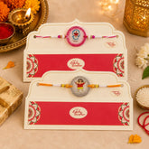 Two Rakhi (handmade ribbons) in decorative envelopes on a festive background with lights and flowers.