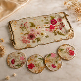 Decorative tray and coasters with floral design on a marble surface