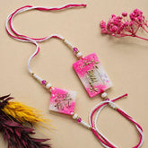 Decorative necklace with pink and white ribbons and floral elements on a beige background