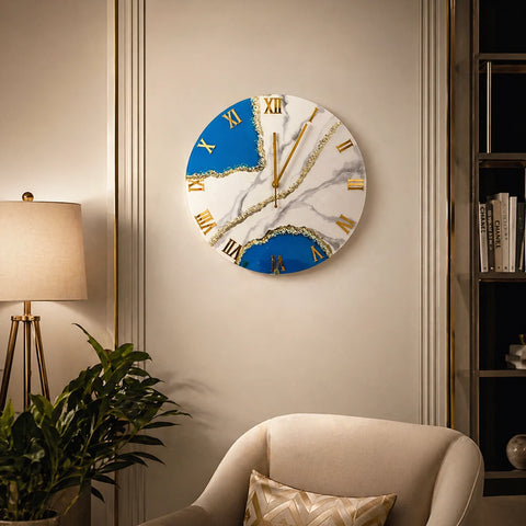 Decorative wall clock with blue and white design on a wall in a room with a lamp and plant.