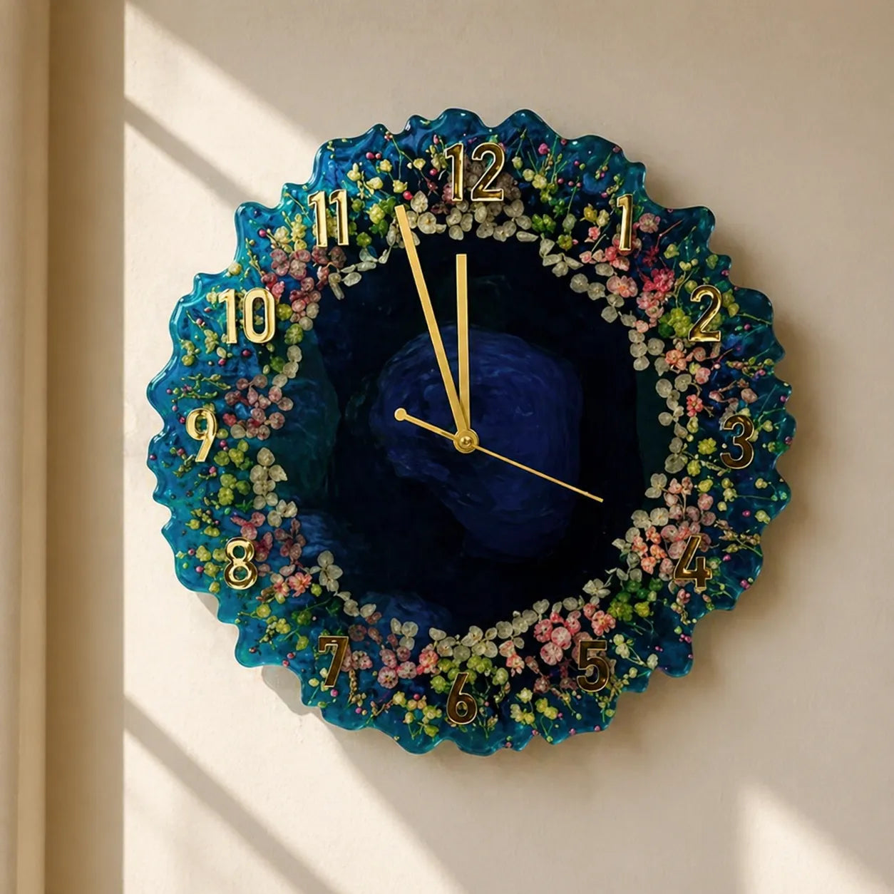 Decorative wall clock with floral design and blue center on a beige wall.
