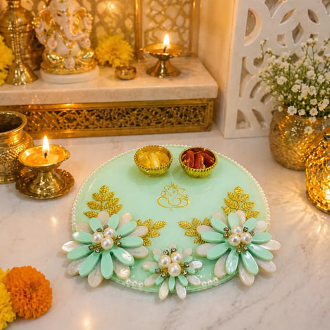 Decorative plate with floral design on a marble surface with candles and decorative items.