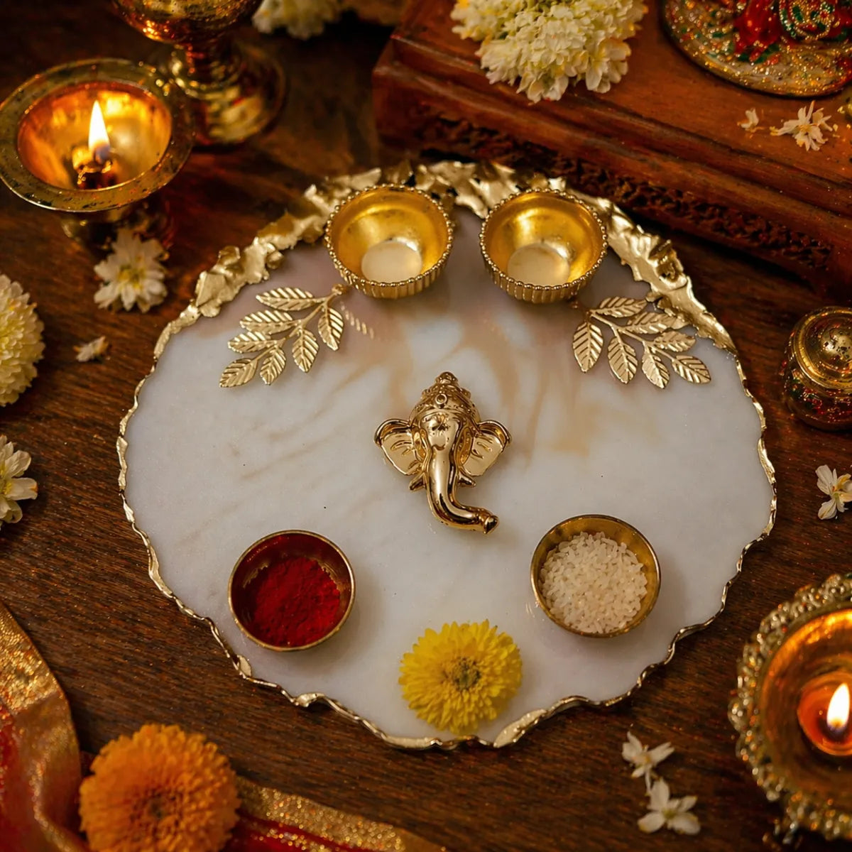 Decorative tray with gold elements, flowers, and candles on a wooden surface