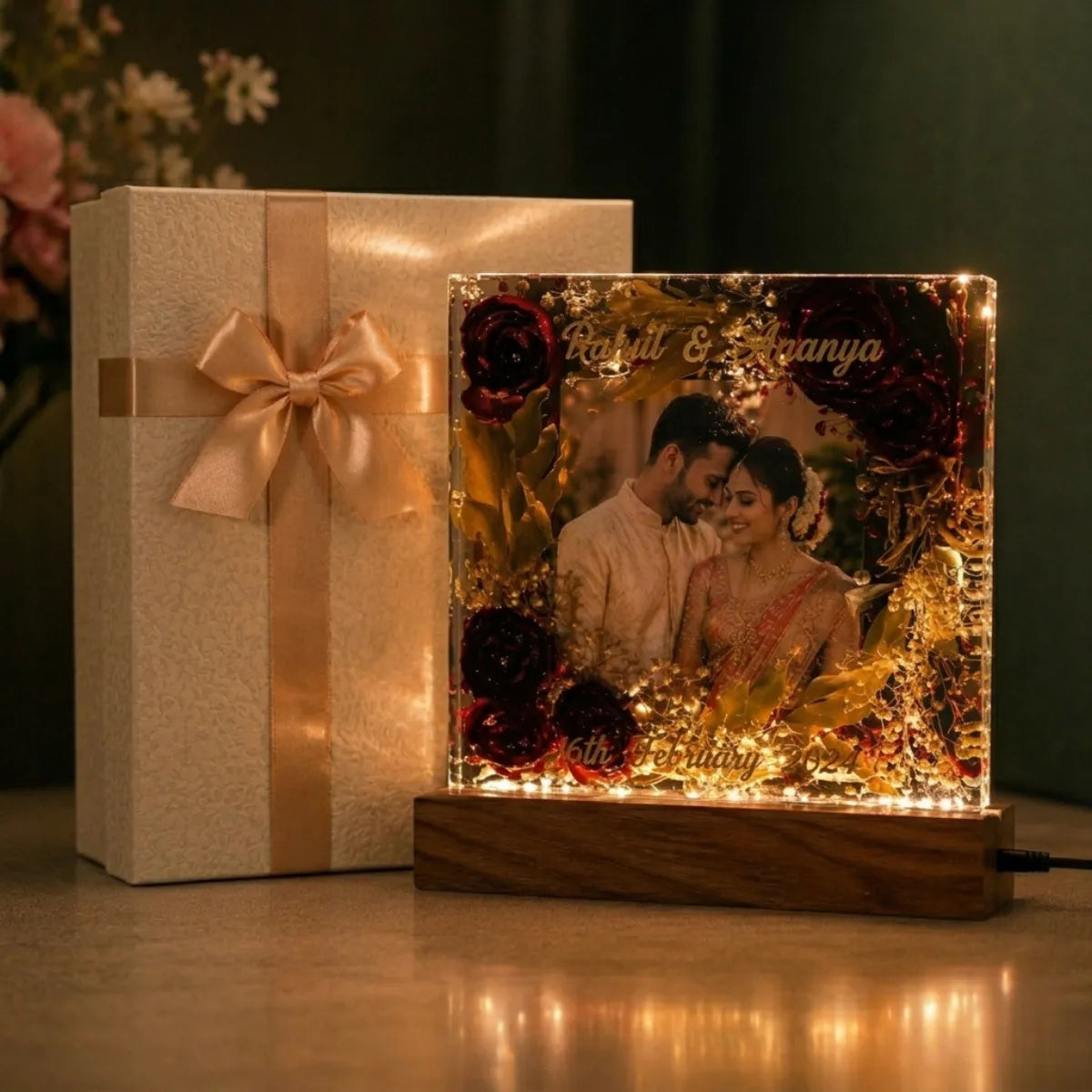 Decorative light box with a couple's photo and a gift box with a bow on a dark background