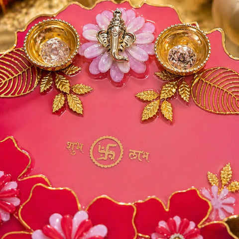 close up resin pooja thali with ganesha design pink red with gold accents festive decorative plate