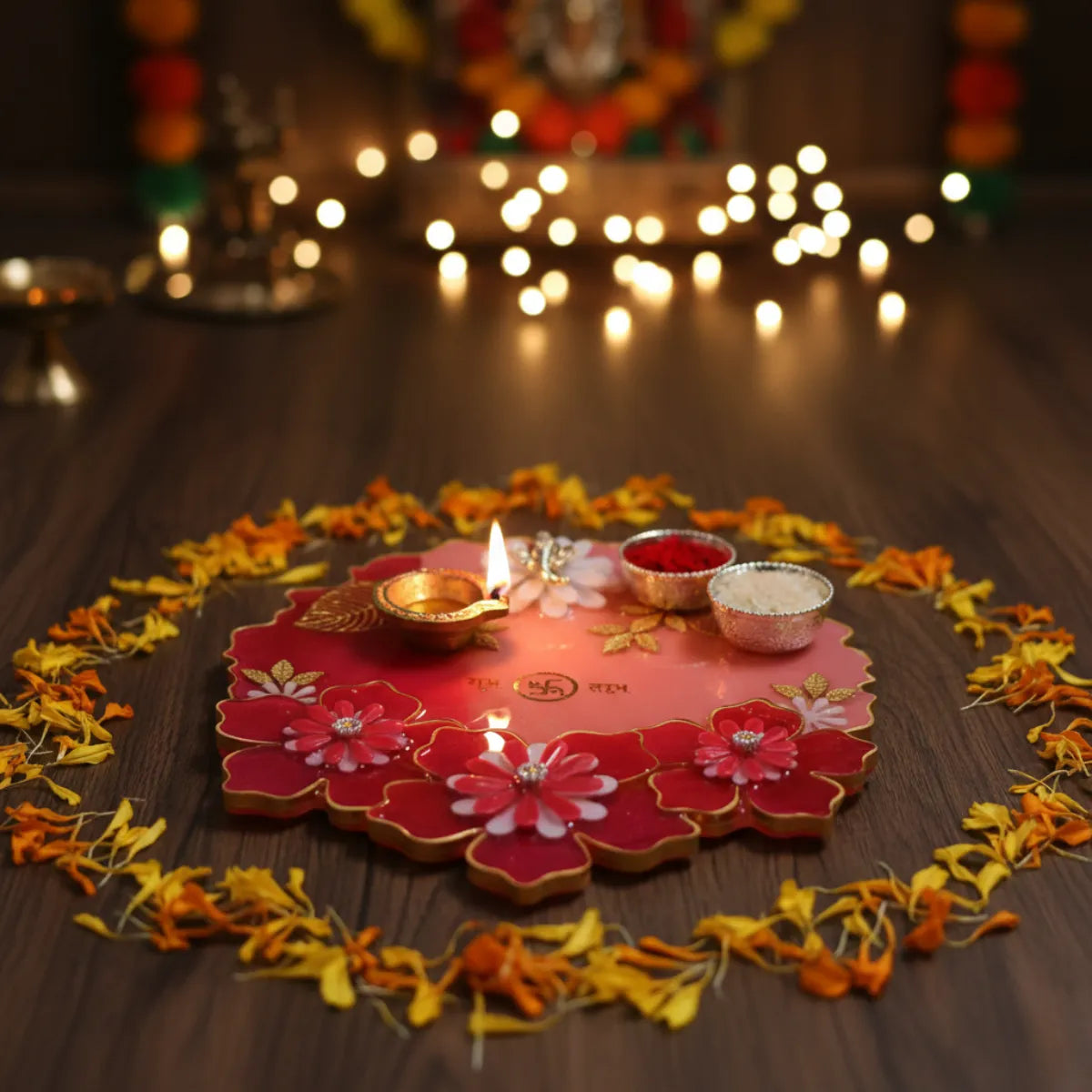 Decorative floral design with lit candles and small containers on a wooden surface, surrounded by blurred lights.