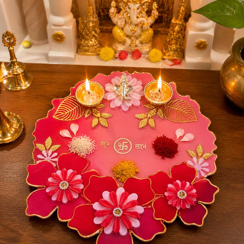 resin pooja thali in pink red with gold accents used with diya and kumkum for festive pooja setup