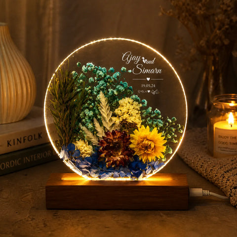 Decorative lamp with pressed flowers and wooden base on a warm-toned background