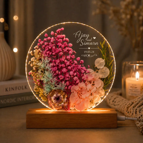 Decorative lamp with flowers and personalized text on a wooden base.