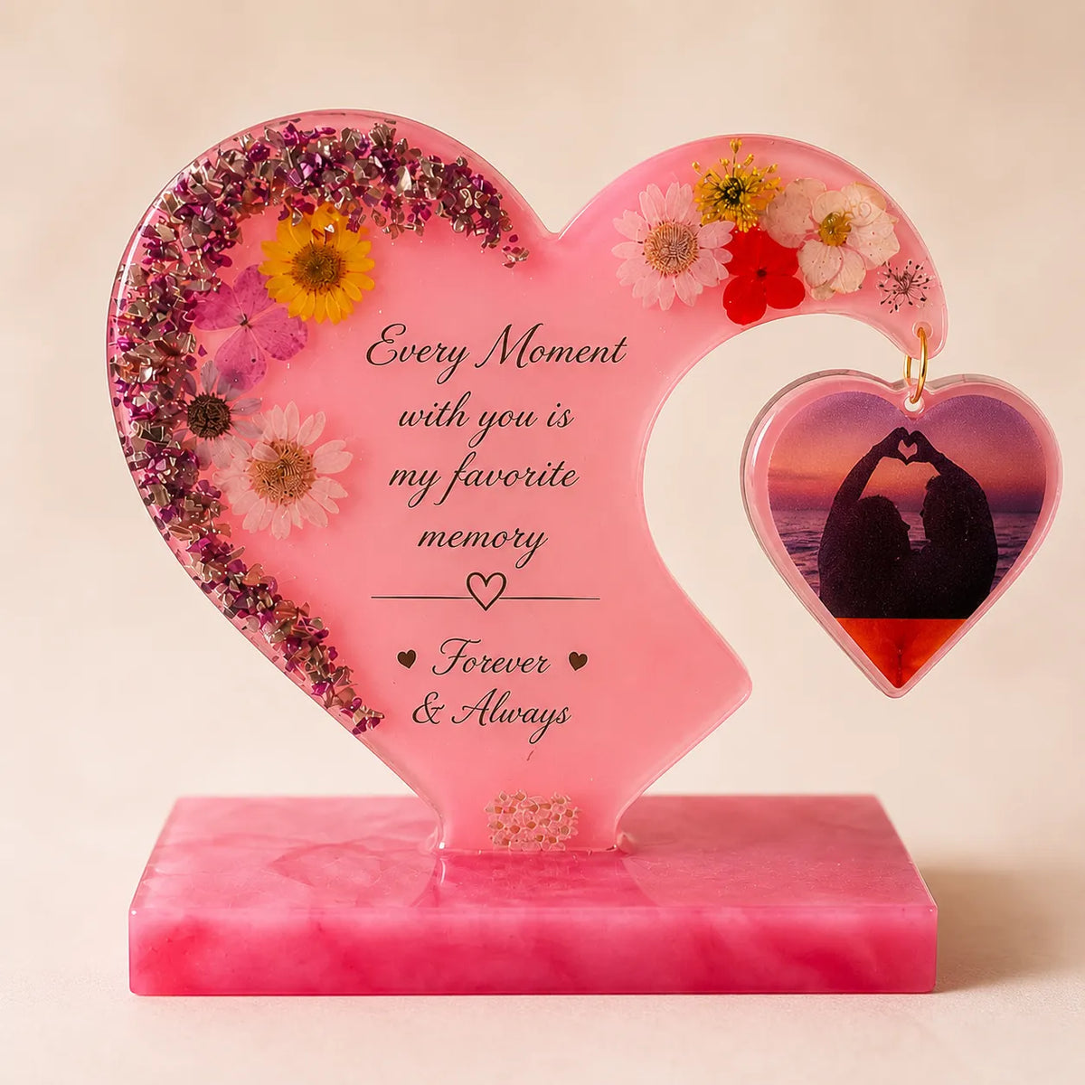 Heart-shaped pink decorative item with flowers and a romantic message on a beige background