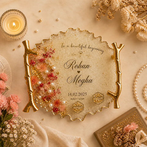 Decorative plate with personalized names and date, surrounded by flowers and a candle on a beige background
