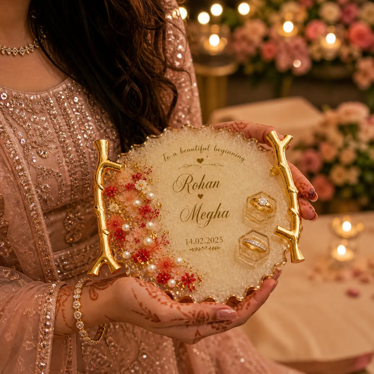 Person holding a decorative plate with engraved names and dates, surrounded by floral decorations.