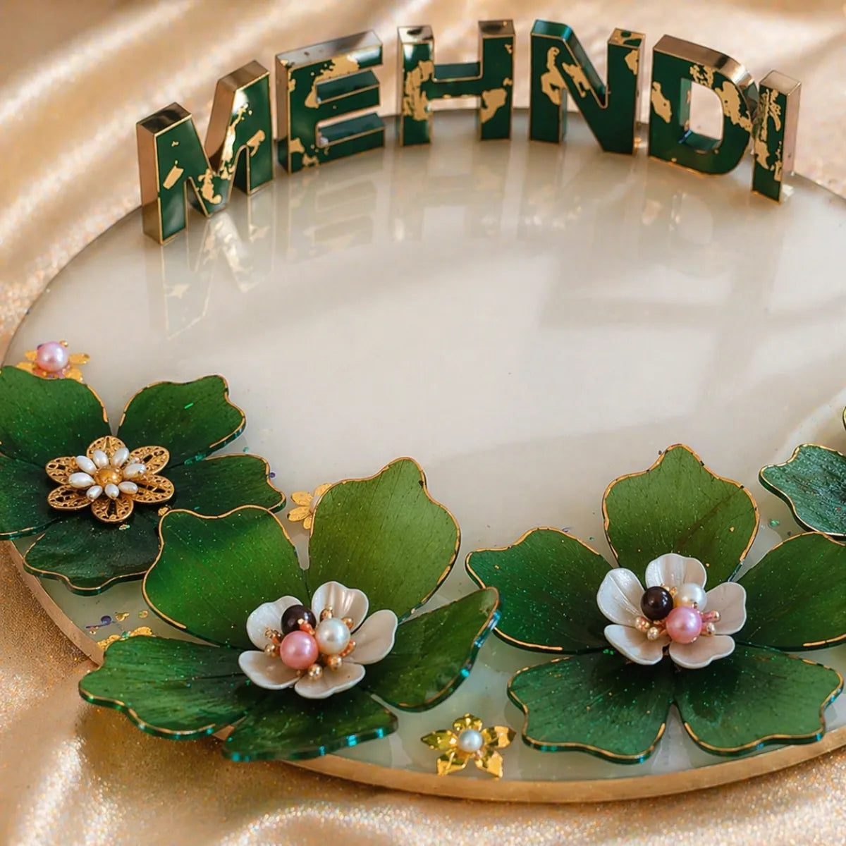 Decorative tray with floral designs and 'MEHNDI' text on a gold background