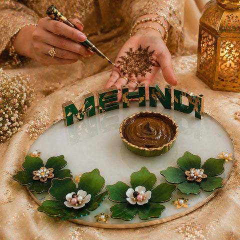 8 inch customized resin mehndi name plate with green floral design used during mehndi ceremony with hand applying henna