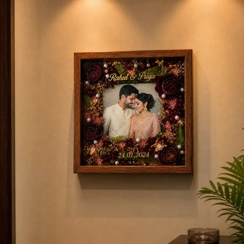 Framed photograph of a couple with floral decorations on a wall.