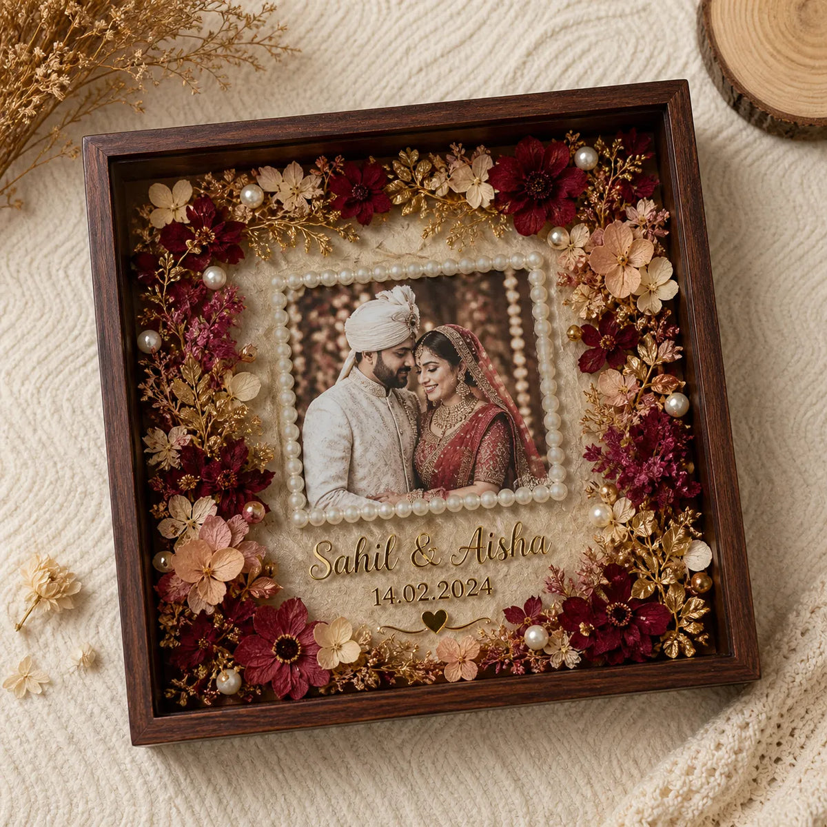 Decorative shadow box with flowers and a couple's photo, featuring names and date.