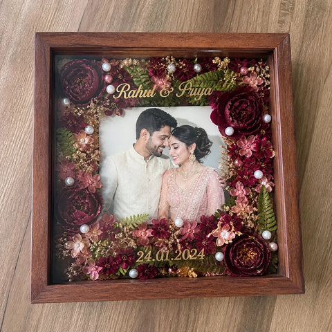 Decorative shadow box with flowers and a couple's photo, featuring names and date.