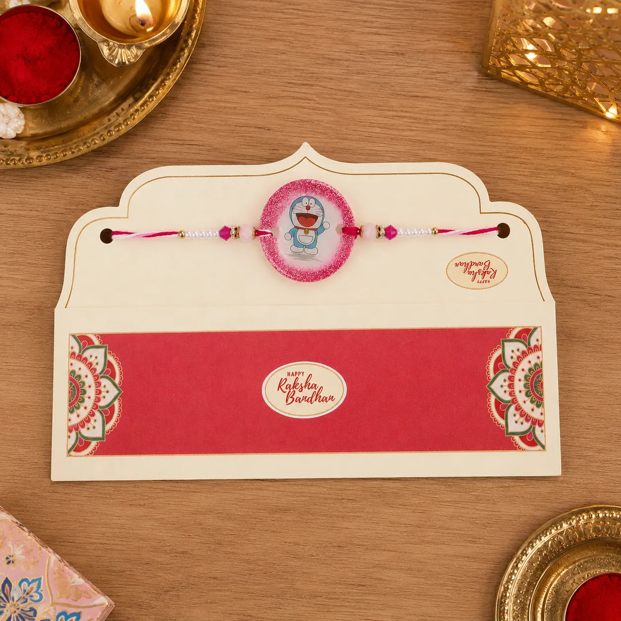 Card with rakhi and a small cartoon character on a wooden surface