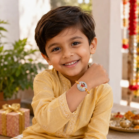 Child wearing a yellow traditional outfit with a decorative bracelet, smiling indoors.
