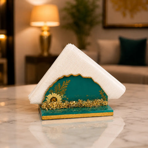 Decorative object resembling a small house with a textured white roof and green base featuring gold accents, placed on a marble surface.