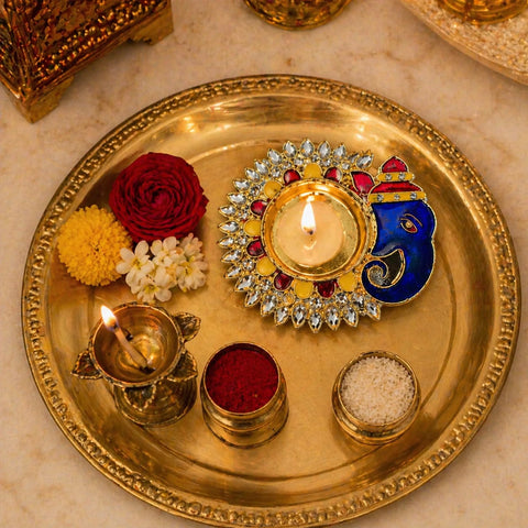 Decorative tray with lit candles, flowers, and colorful elements on a marble surface