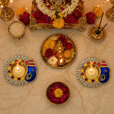 Decorative setup with lit candles, flowers, and a decorative tray on a beige surface.