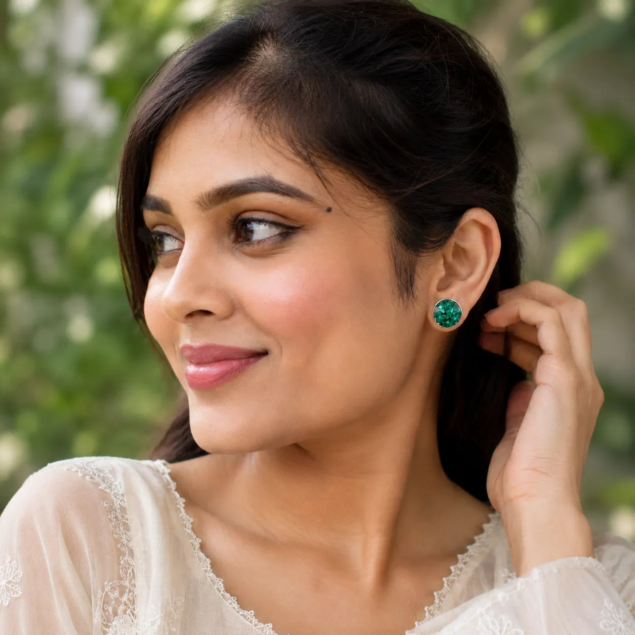 Indian woman wearing handmade emerald green crystal resin stud earrings in a natural daylight lifestyle fashion look