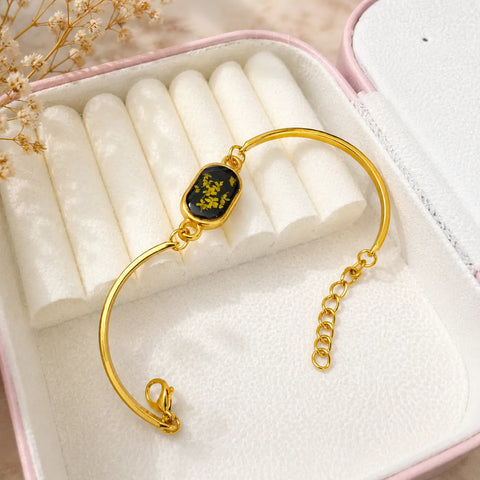 Gold bracelet with a black stone in a jewelry box