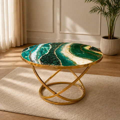 Coffee table with green and gold design in a room with curtains and a plant.