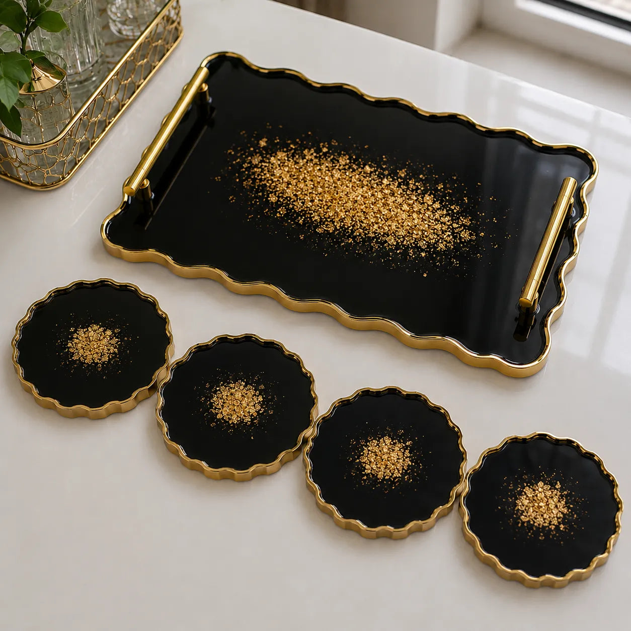 Black and gold tray with four matching coasters on a white surface.