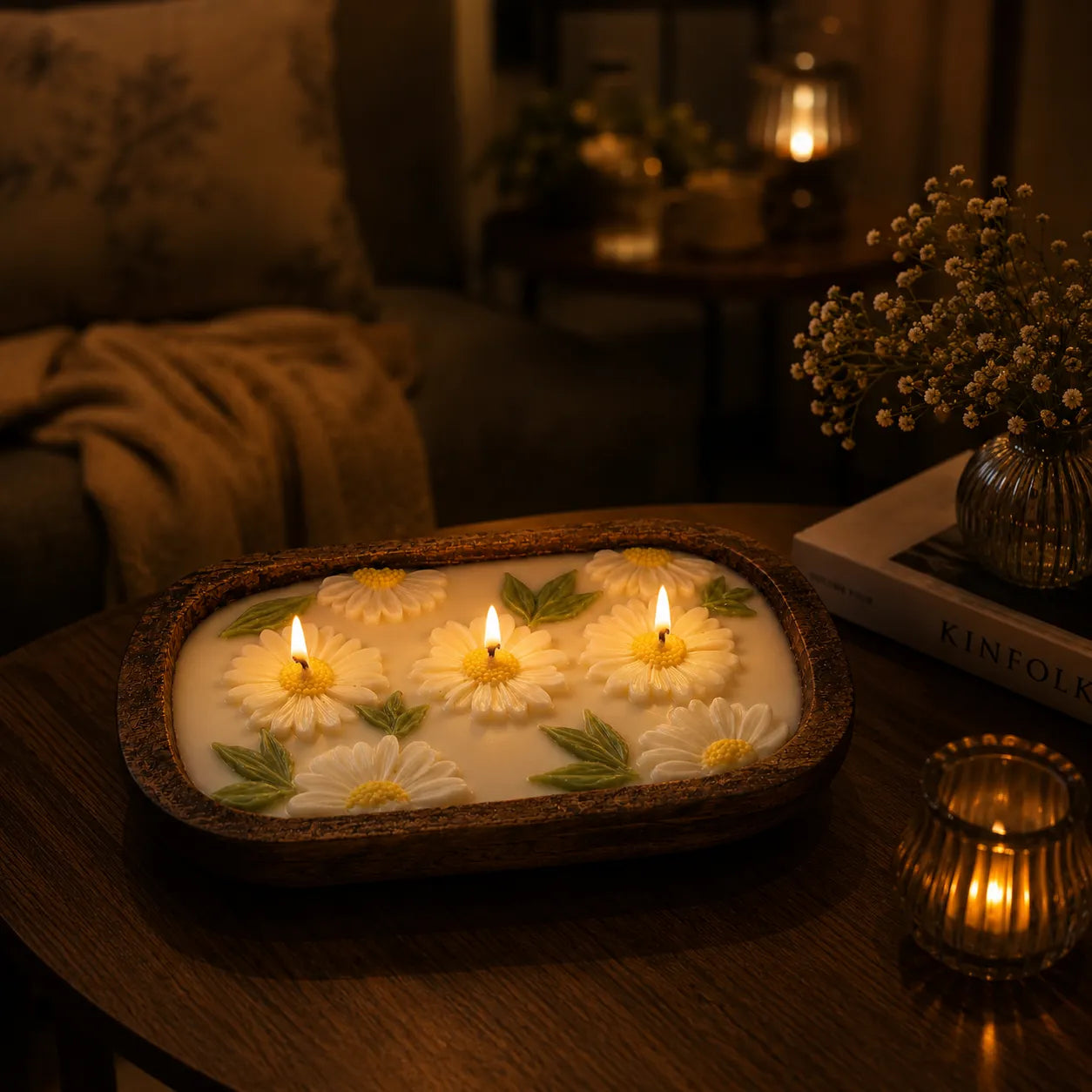 Decorative candle with floral design on a wooden surface in a cozy room.