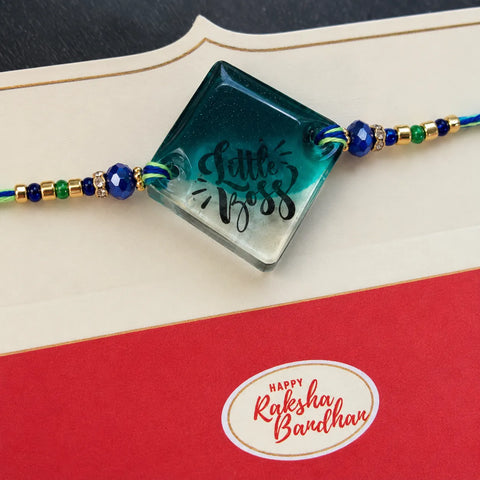 Decorative bracelet with 'Little Boss' on a red card with 'Happy Raksha Bandhan' text.