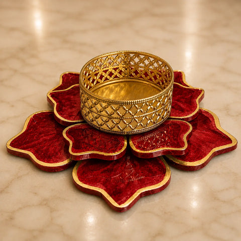 Decorative gold bangle on a red lotus-shaped stand against a beige background