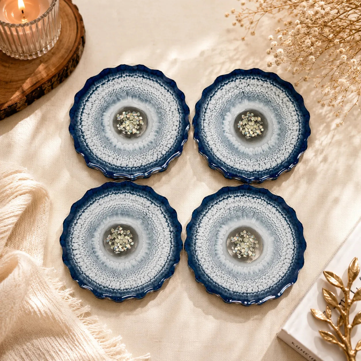 Four blue and white ceramic coasters on a textured surface with decorative elements.