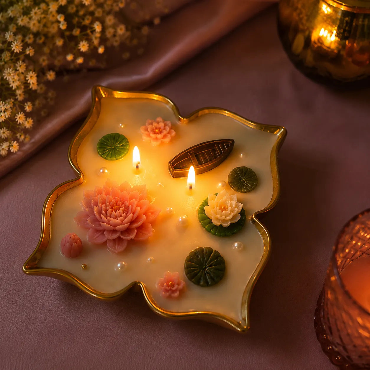 Decorative candle with floral designs on a pink surface