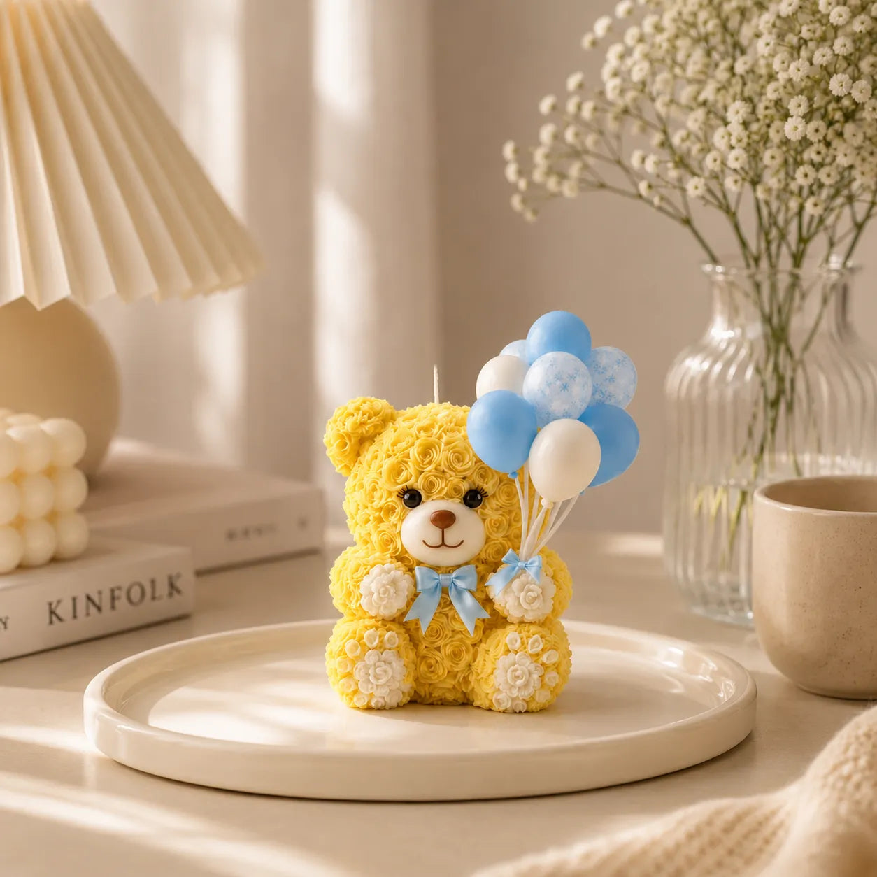 Yellow teddy bear with balloons on a white plate in a cozy room setting.