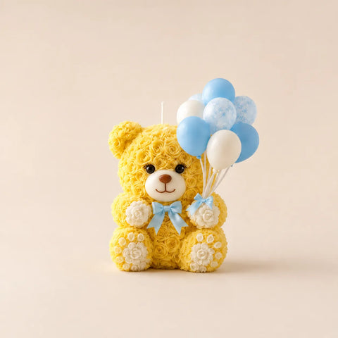 Yellow teddy bear candle with balloons on a beige background