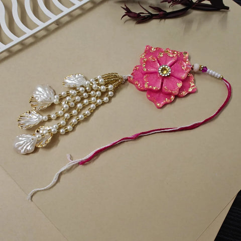 Decorative pink flower and pearl necklace on a beige surface