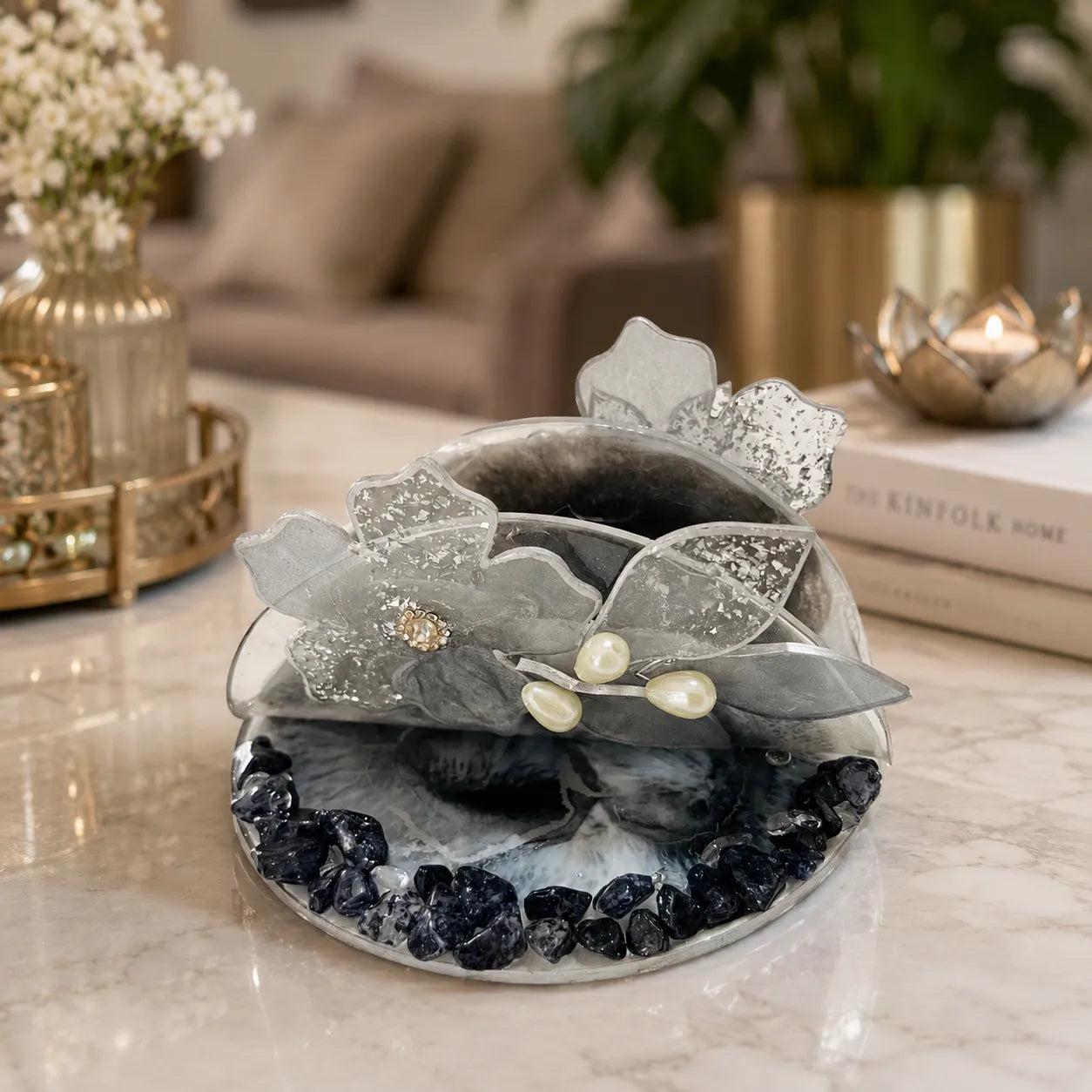 Decorative item with flowers and stones on a marble surface