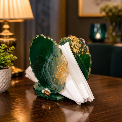 Decorative green stone with gold accents on a wooden surface, with a blurred background of a room setting.