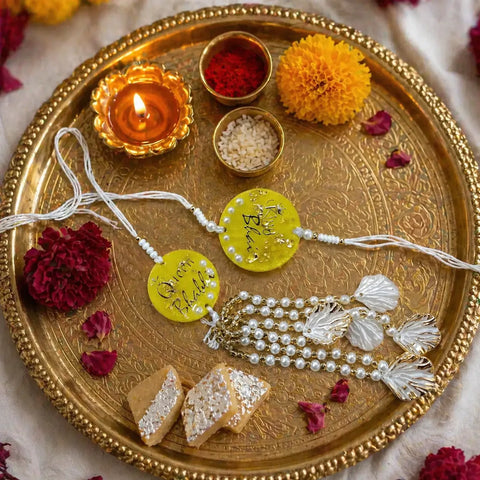 handmade yellow resin bhai bhabhi rakhi set placed on pooja thali with diya flowers and festive raksha bandhan decoration