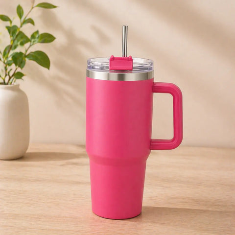 Hot pink stainless steel insulated tumbler with handle and steel straw, 1200ml large capacity travel mug for hot and cold drinks on wooden surface