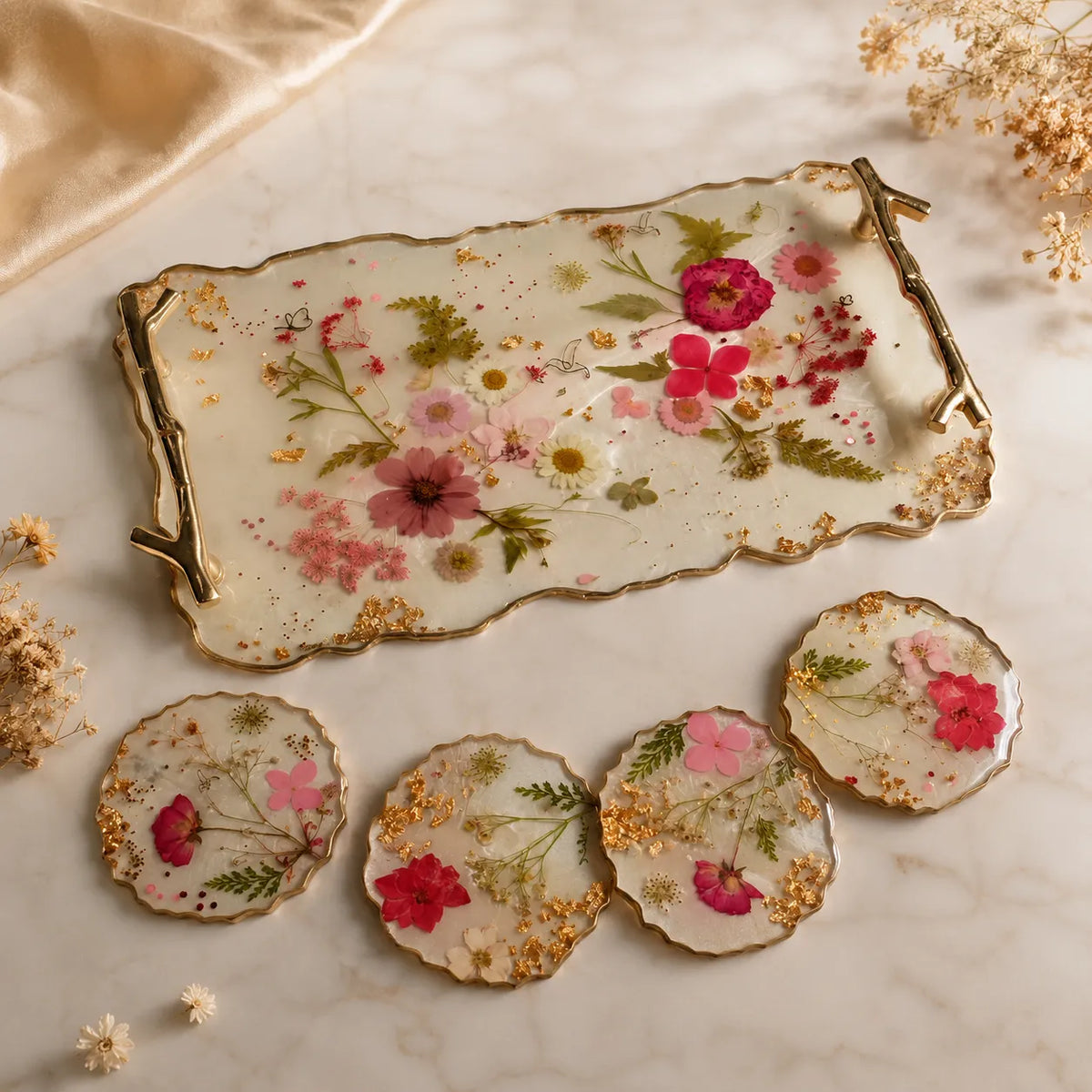 Decorative tray and coasters with floral design on a marble surface