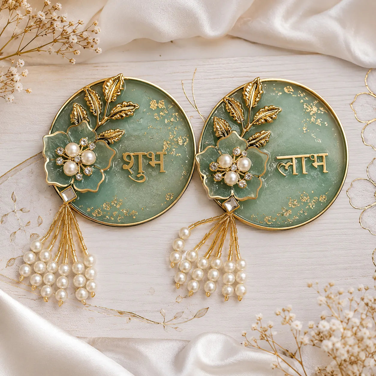 Pair of decorative earrings with floral designs and pearl details on a light background.