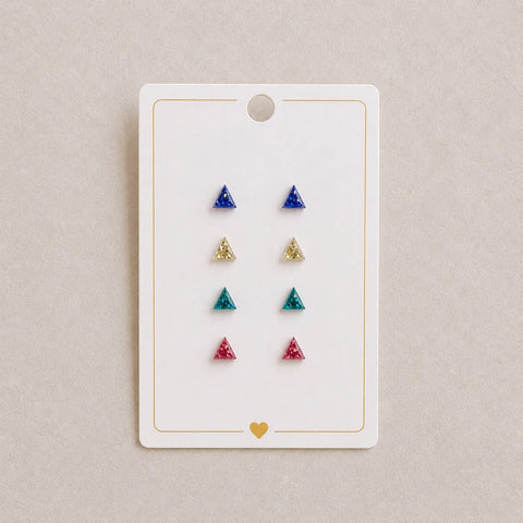 Set of triangle-shaped earrings on a display card with a beige background