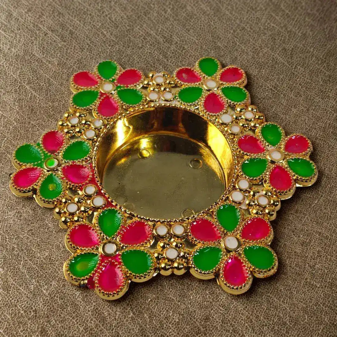 Decorative Diwali lamp with gold base and colorful flower-shaped design on a brown background